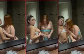 Conteúdo adulto com temática lésbica, onde amigas trocam beijos e carícias em ambiente de banheiro